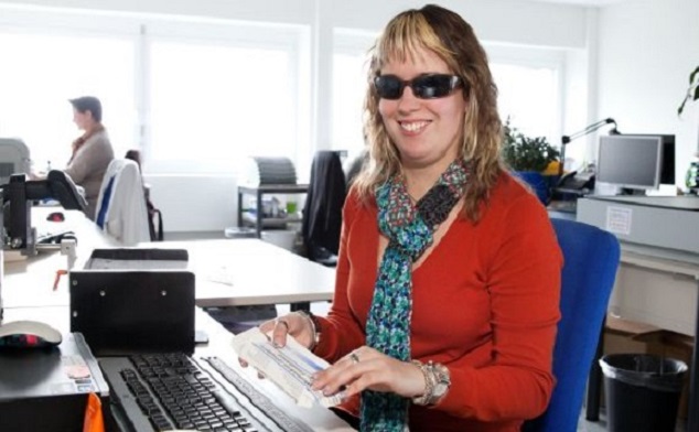 Sehbehinderte Frau am Schreibtisch beim Arbeiten Sehbehinderte Frau am Schreibtisch beim Arbeiten